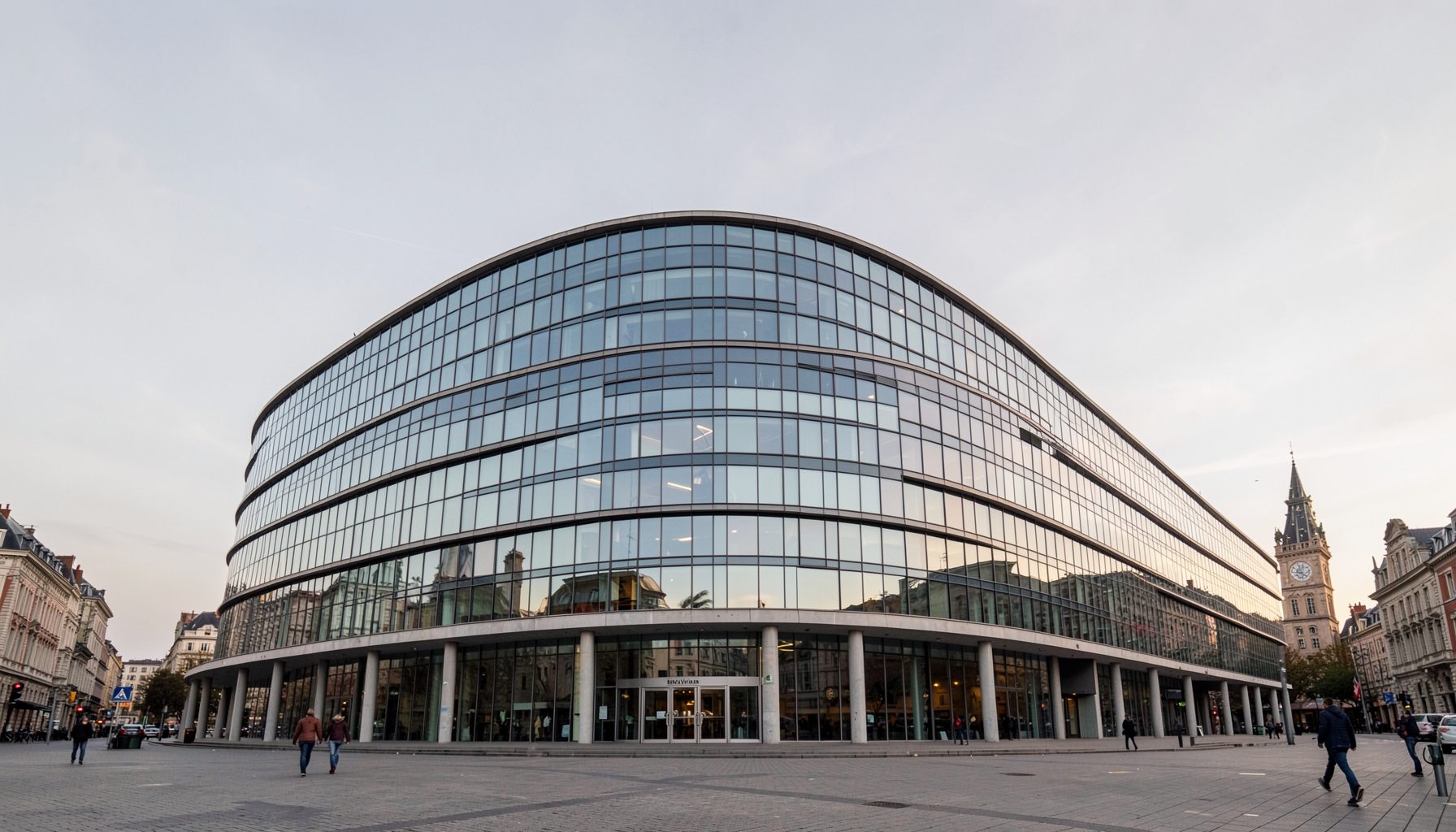 The Berlaymont building in Brussels seen from a low angle against a pale grey sky, its curved glass facade reflecting soft light